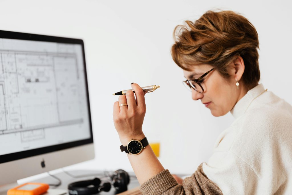 Confident businesswoman using computer for architectural analysis in a modern office